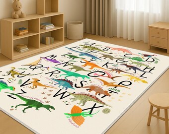May include: A rectangular rug with a cream background features the alphabet and colorful dinosaur illustrations. The letters are in black, and the dinosaurs are in various colors, including green, orange, and blue. The rug is designed for a child's room.