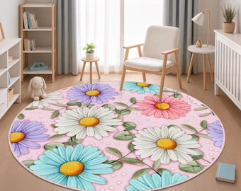 May include: A circular rug with a daisy floral design. The rug displays large daisies in white, pink, blue, and purple with yellow centres, set against a light pink background with white polka dots. Green leaves and stems are also present.
