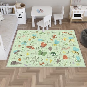 Peut inclure: Tapis pour enfants vert clair avec l'alphabet et des illustrations d'insectes. Le tapis a un motif à pois blancs et présente des fourmis, des abeilles, des papillons et des araignées. Le tapis est dans une chambre d'enfant.