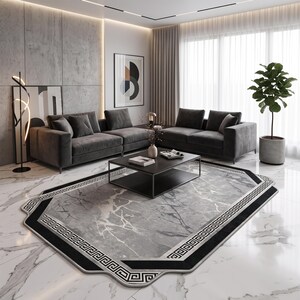 May include: A large area rug featuring a gray marble-patterned center with a distinct black border decorated with a white Greek key geometric motif. The rug has an octagonal shape with cut corners and is positioned on a white marble floor.