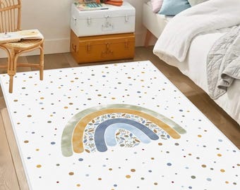 May include: A rectangular white rug with a rainbow design in shades of blue, yellow, and green. The rug is decorated with scattered dots in various colors. This rug is suitable for a child's bedroom or playroom.
