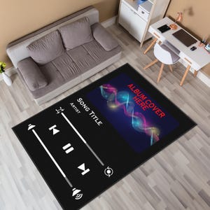 May include: Black rectangular rug with a music player interface design. The rug features white play, pause, skip, and volume icons. The top right corner has a colorful album cover design with the text "ALBUM COVER HERE".