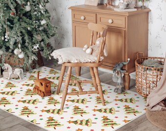 May include: A rectangular Christmas-themed rug featuring a repeating pattern of green Christmas trees, red stars, and red baubles on a white background. A wooden toy train sits on the rug near a wooden chair and Christmas tree.