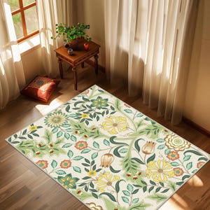 May include: A rectangular rug with a floral pattern featuring yellow, green, and orange flowers on a cream background. The rug is placed on a hardwood floor, with a small wooden table and a window in the background.