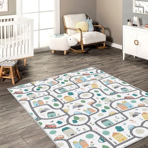May include: A rectangular play rug with a road map design. The rug features a white background with gray roads, colorful houses, trees, and cars. The design is child-friendly and suitable for a playroom or nursery.