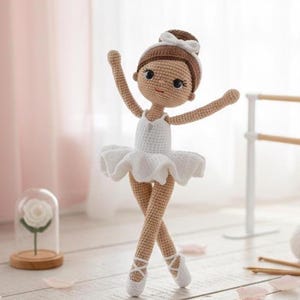 Puede incluir: Muñeca de bailarina de ganchillo hecha a mano con tutú blanco, zapatillas de ballet y moño marrón. La muñeca tiene una expresión dulce y posa con los brazos levantados. La muñeca mide aproximadamente 20 cm de alto.