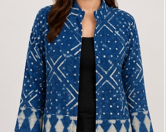 May include: A blue open-front jacket featuring a white geometric pattern of dots and crosses. The garment has three-quarter length sleeves and a straight hemline decorated with a repeating diamond motif in a lighter shade of blue and white.