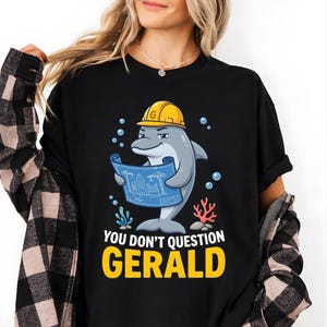 May include: A white ceramic mug with a black handle and the text "But First, Coffee" in a bold, black font. The mug is set against a blurred background, suggesting a cosy setting.