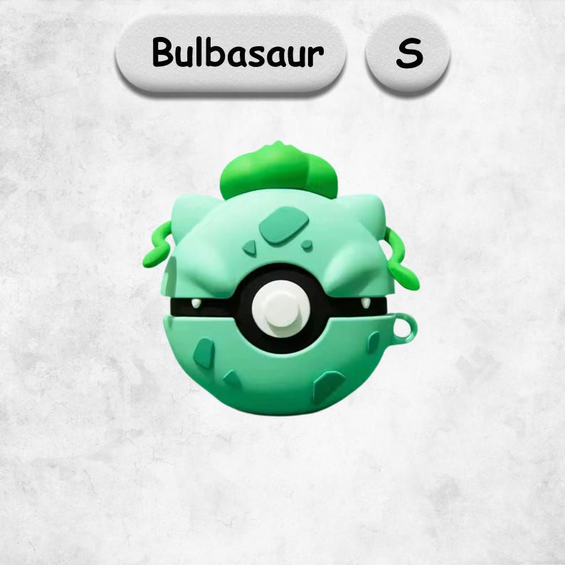 May include: A light green protective case for wireless earbuds shaped like a spherical creature with a bulb on top. The case features a central circular button, dark green spots, and a small side loop. The text Bulbasaur and S appear above.