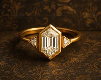 May include: A gold ring featuring a large, rectangular-cut diamond center stone set in a hexagonal bezel. Two triangular diamonds flank the center stone. The ring is set against a dark, patterned background.