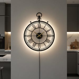 May include: A black, round wall clock with Roman numerals and gold-colored hands. The clock has a decorative, openwork design and is illuminated with a soft, warm light. The clock is hanging on a light-colored wall.