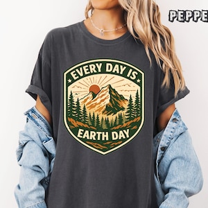 May include: A white ceramic mug with a black handle and the text "But First, Coffee" in a handwritten style. The mug is on a white surface. The mug is approximately 4 inches tall.