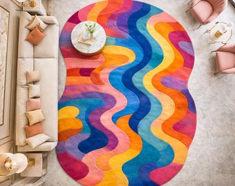 Puede incluir: Una vibrante alfombra abstracta con un diseño ondulado y colorido. La alfombra presenta un espectro de colores, incluyendo rosa, naranja, amarillo, azul y morado. La forma única y la audaz paleta de colores de la alfombra la convierten en una pieza destacada para cualquier espacio habitable.