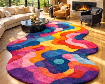 Puede incluir: Una vibrante alfombra abstracta con un diseño ondulado y colorido. La alfombra presenta tonos de morado, rosa, naranja, amarillo y azul. La alfombra está colocada sobre un suelo de madera en un salón, con un sofá, sillas y una mesa de centro.