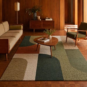 May include: A geometric area rug with a mid-century modern design. The rug features a color block pattern in shades of green, brown, and cream. The rug is placed in a living room with a sofa, chair, and wooden furniture.