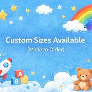 May include: A whimsical illustration on a blue background with clouds, stars, and a rainbow. The image includes a rocket, ABC blocks, and a teddy bear. Text reads "Custom Sizes Available (Made to Order)".