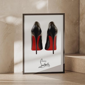 May include: A framed rectangular wall art print featuring two black high-heeled pumps with signature red soles, positioned side-by-side against a white background, with the black Christian Louboutin logo printed clearly at the bottom center.
