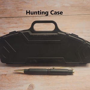 May include: Black hard plastic case with a handle, labeled "Hunting Case". A black pen with a gold tip is lying in front of the case.