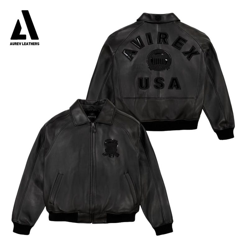 Puede incluir: Chaqueta de cuero negra con cremallera, cuello y pu&ntilde;os y dobladillo acanalados. La parte trasera de la chaqueta presenta el texto "AVIREX USA" y un emblema circular. El logotipo de Aurev Leathers est&aacute; en la esquina superior izquierda.