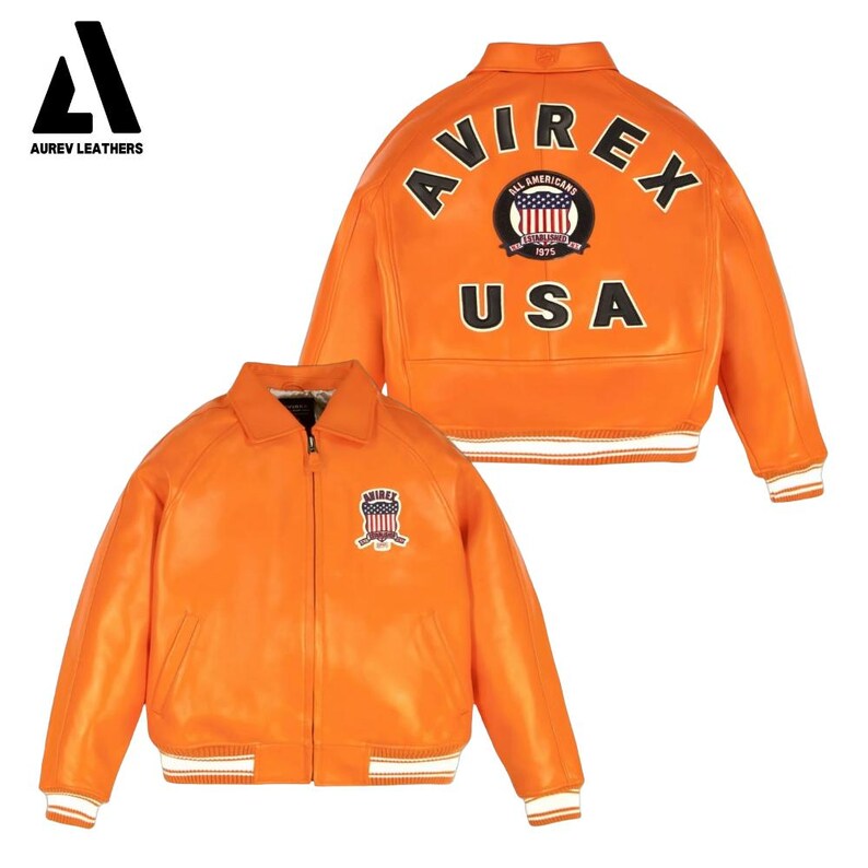 May include: Orange leather jacket with white stripes on the cuffs and hem. The back of the jacket features the text "AVIREX" and "USA" with a circular emblem. The front has a smaller emblem. AUREV LEATHERS logo is in the top left corner.