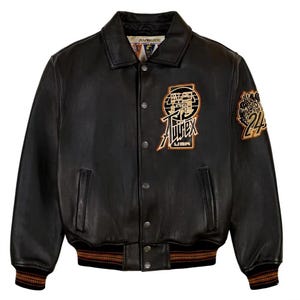 Puede incluir: Chaqueta de cuero negra con cierre de botones, cuello y pu&ntilde;os y dobladillo acanalados. Cuenta con parches bordados con el texto "AVIREX USA" y el n&uacute;mero "24". Un estilo cl&aacute;sico de chaqueta bomber.