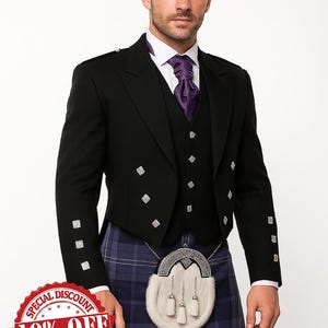 Puede incluir: Chaqueta y chaleco formales negros con detalles de diamantes plateados, combinados con una corbata morada y un kilt a cuadros azul y morado. Un sporran blanco con borlas cuelga de una cadena. También aparece el texto "FAST SHIPPING".