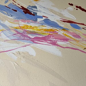 May include: Abstract painting with a beige background and dynamic brushstrokes in shades of blue, pink, yellow, white, and maroon. The artwork features a textured surface with visible paint layers, creating a sense of depth and movement. The composition is a modern, expressive piece.