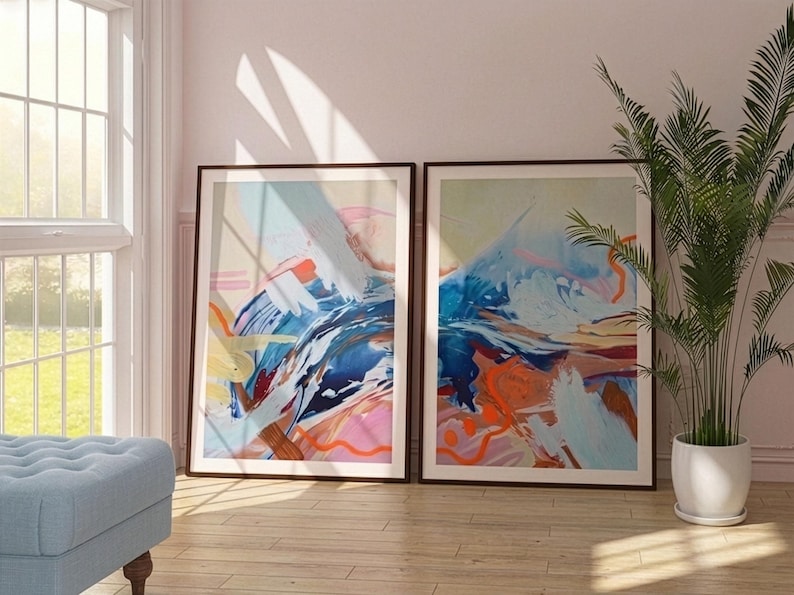 Puede incluir: Dos l&aacute;minas de arte mural rectangulares enmarcadas con composiciones abstractas de pinceladas superpuestas en tonos azul, naranja, rosa y blanco. Las obras muestran formas din&aacute;micas y fluidas con texturas de pintura en marcos marr&oacute;n oscuro.