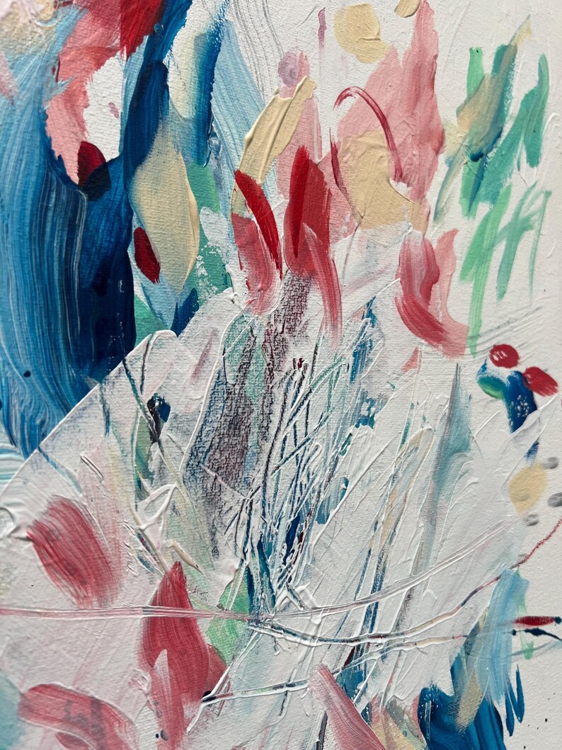 Op de afbeelding: Een abstract schilderij op canvas met dikke, getextureerde penseelstreken in tinten wit, felblauw, diep marineblauw, zachtroze, rood en lichtgeel. De compositie toont gelaagde verfaanbrengingen met zichtbare ribbels en diverse markeringen.