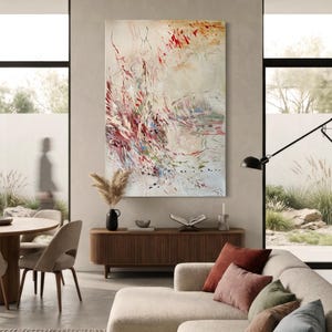 May include: A large rectangular wall art piece featuring an abstract composition with energetic brushstrokes in shades of red, muted green, and blue against a cream-colored background, displayed vertically on a neutral-toned wall.