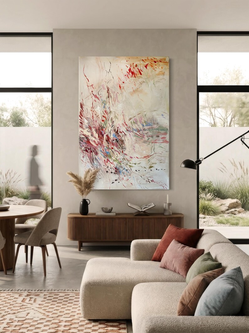 May include: A large rectangular wall art piece featuring an abstract composition with energetic brushstrokes in shades of red, muted green, and blue against a cream-colored background, displayed vertically on a neutral-toned wall.