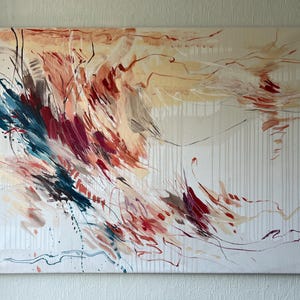 May include: Abstract canvas art featuring a dynamic composition of brushstrokes in shades of red, blue, and beige. The artwork has a textured appearance with vertical white lines and a flowing, expressive style. The painting is stretched on a rectangular frame.
