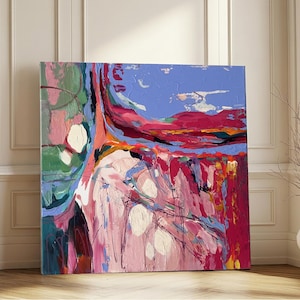 May include: Abstract square canvas art with a vibrant color palette. The artwork features a blend of pink, red, blue, and green hues, with white circular accents. The painting is displayed against a white wall and wooden floor.