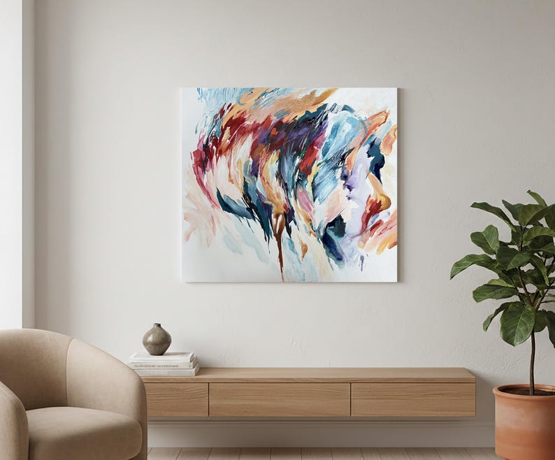 May include: Abstract painting on canvas featuring a profile portrait. The artwork uses a palette of blues, reds, oranges, and whites, with visible brushstrokes creating a dynamic and expressive composition. The painting is displayed on a white wall.