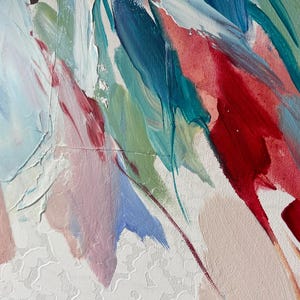 Puede incluir: Primer plano de una pintura abstracta con pinceladas gruesas. La obra presenta una paleta de colores que incluye rojo, azul, verde y blanco, aplicada sobre un lienzo blanco texturizado. La pintura parece estar aplicada con un estilo din&aacute;mico y expresivo.