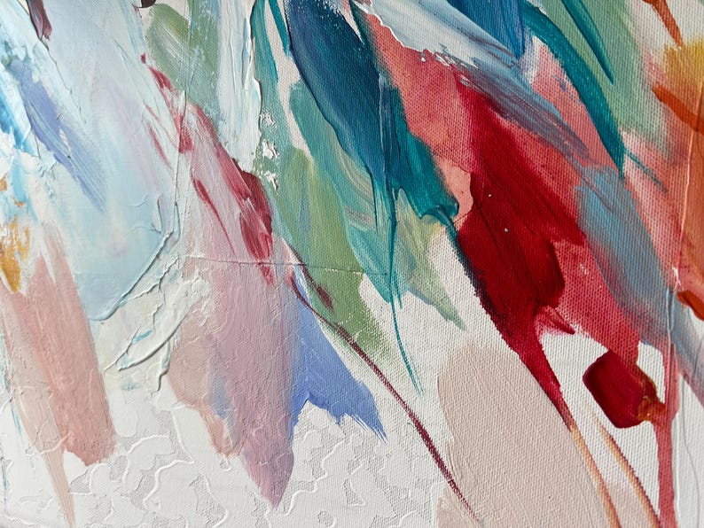 Puede incluir: Primer plano de una pintura abstracta con pinceladas gruesas. La obra presenta una paleta de colores que incluye rojo, azul, verde y blanco, aplicada sobre un lienzo blanco texturizado. La pintura parece estar aplicada con un estilo din&aacute;mico y expresivo.