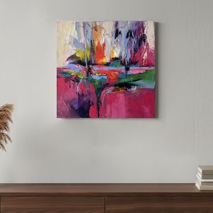 May include: Abstract oil painting on canvas. The artwork features a vibrant composition of colors, including shades of pink, green, blue, yellow, and purple. The painting has a textured appearance, with visible brushstrokes and a dynamic, expressive style.