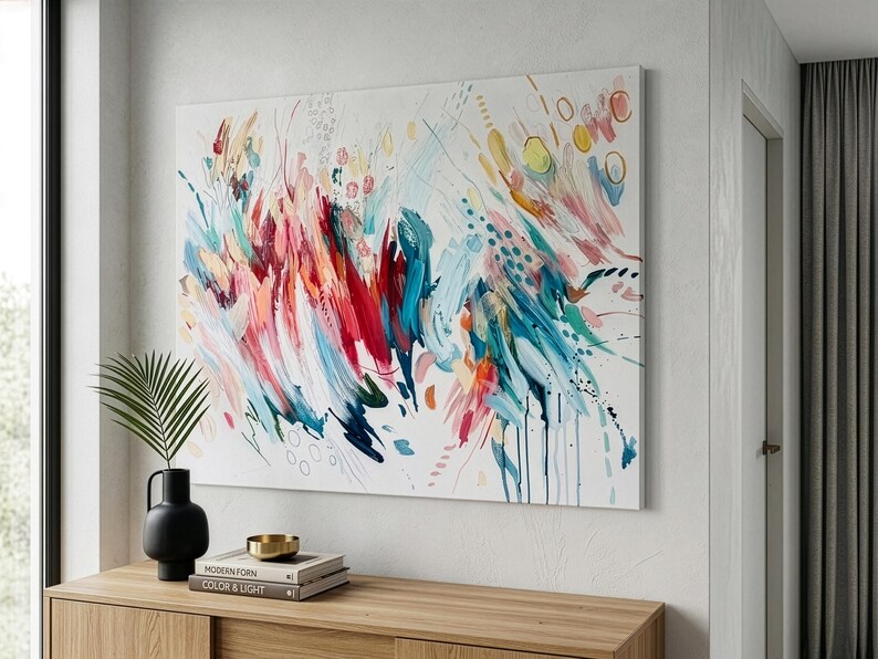 Pode incluir: Uma grande pintura retangular em tela apresentando uma composi&ccedil;&atilde;o abstrata de pinceladas energ&eacute;ticas em tons vibrantes de vermelho, azul-petr&oacute;leo, azul, amarelo e rosa sobre um fundo branco, com pontos espalhados e padr&otilde;es de linhas circulares.