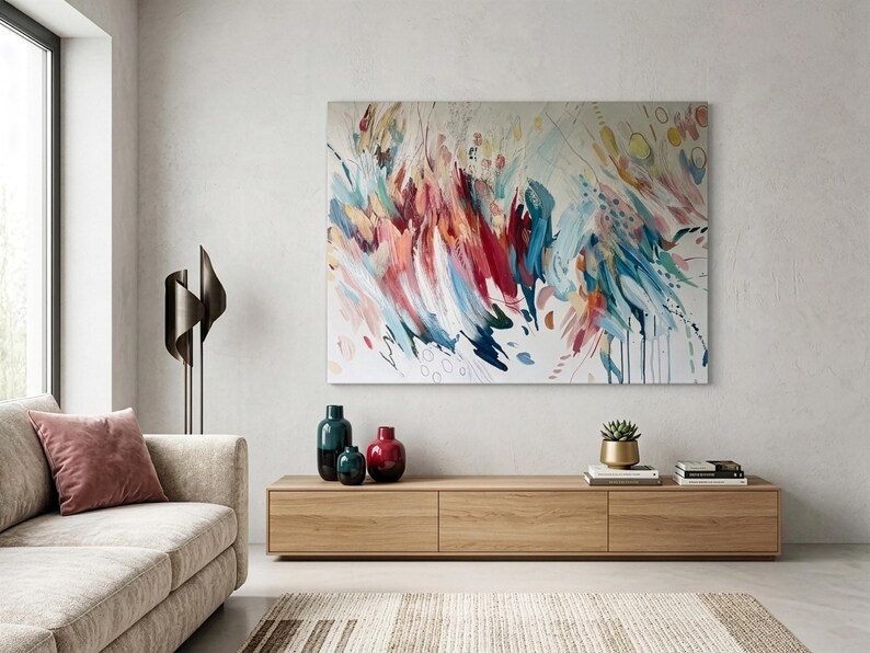 Pode incluir: Uma grande pintura retangular em tela com pinceladas abstratas em tons de vermelho, azul, azul-petr&oacute;leo e amarelo sobre um fundo branco. A obra exibe linhas din&acirc;micas e motivos circulares, criando uma sensa&ccedil;&atilde;o de movimento na superf&iacute;cie.