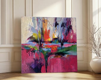 Puede incluir: Pintura abstracta cuadrada con una paleta de colores vibrantes. La obra presenta pinceladas audaces en tonos de rosa, rojo, azul, verde y amarillo. El lienzo está apoyado contra una pared blanca y un suelo de madera.