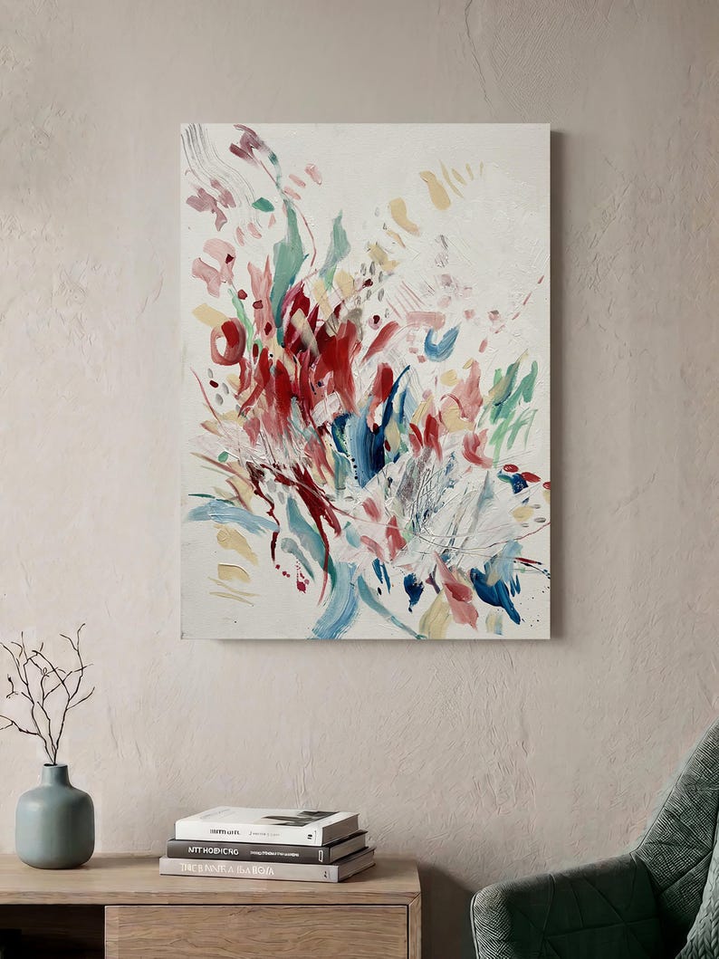 Op de afbeelding: Een rechthoekig schilderij op canvas met een abstracte compositie van energieke penseelstreken in tinten dieprood, zachtroze, gedempt blauw en lichtgeel tegen een getextureerde gebroken witte achtergrond, wat zorgt voor een dynamisch beeld.
