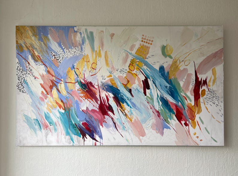 Puede incluir: Pintura abstracta con fondo blanco y pinceladas coloridas. La obra presenta salpicaduras de azul, rosa, amarillo y rojo, con toques de oro y plata. La pintura tiene una sensaci&oacute;n din&aacute;mica y en&eacute;rgica.