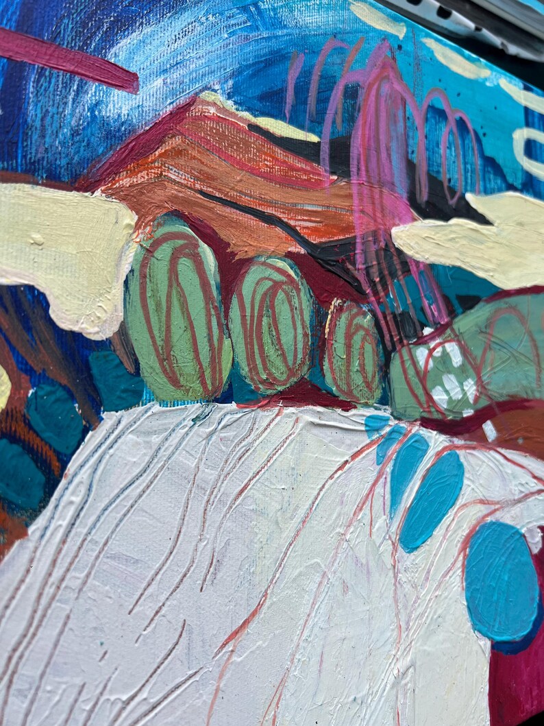 May include: Abstract acrylic painting on canvas. The artwork features a landscape with a mountain range in shades of orange and brown, green rounded shapes, and a white textured foreground. The sky is a mix of blue and turquoise with pink accents.