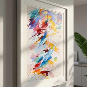 May include: A framed abstract painting featuring energetic brushstrokes in vibrant shades of red, yellow, blue, and soft pink against a cream background. The composition includes scattered circular motifs and fine line details within a white frame.