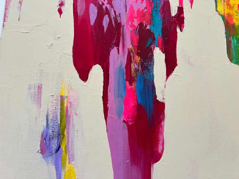 May include: Abstract artwork featuring a cream backdrop with vibrant strokes of magenta, pink, blue, yellow, and purple. The paint drips and blends, creating a dynamic and textured piece.
