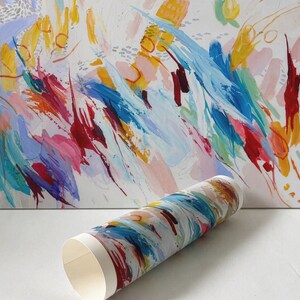 May include: A rectangular canvas print featuring an abstract painting with vibrant brushstrokes in yellow, blue, red, and pink on a white background, accompanied by a rolled paper print displaying the same colourful, expressive artistic pattern.