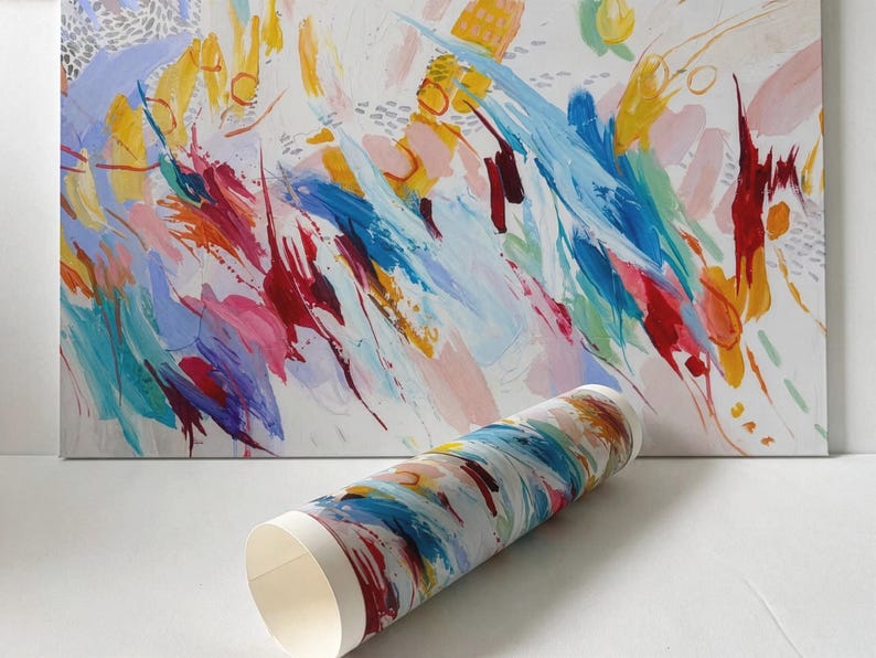 May include: A rectangular canvas print featuring an abstract painting with vibrant brushstrokes in yellow, blue, red, and pink on a white background, accompanied by a rolled paper print displaying the same colourful, expressive artistic pattern.