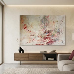 May include: A large rectangular abstract painting featuring a dynamic composition of sweeping brushstrokes in shades of crimson, soft pink, muted green, and blue against a creamy off-white background, displayed on a light-colored wall.
