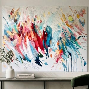 Pode incluir: Uma tela retangular grande apresentando uma pintura abstrata com pinceladas energ&eacute;ticas e amplas em tons vibrantes de vermelho, rosa, azul-petr&oacute;leo, azul e amarelo sobre um fundo branco, acentuado por pequenos pontos e linhas finas.