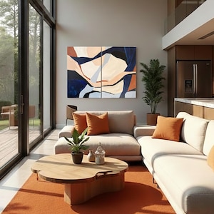 May include: A modern living room with large windows and an open floor plan. The room features a beige sectional sofa with orange throw pillows, a wooden coffee table, and an orange rug. Artwork with blue, beige, and orange tones hangs on the wall.